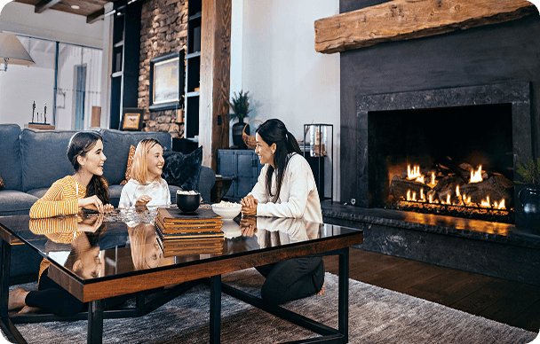family at table enjoying the warmth of their propane fireplace